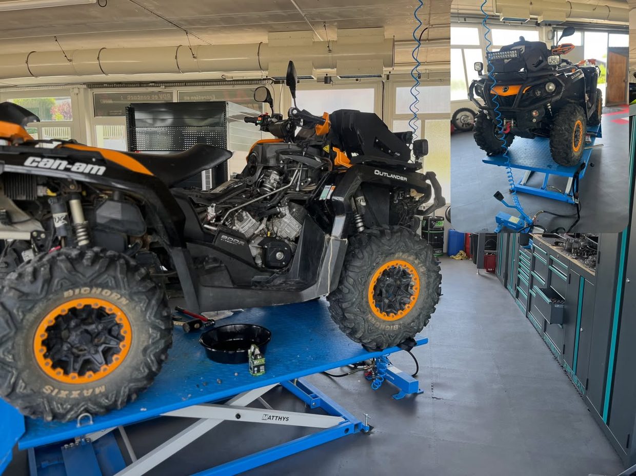 Quad Can-Am Outlander sur le pont à quatre roues de l’atelier AJ Moto, en cours de vidange